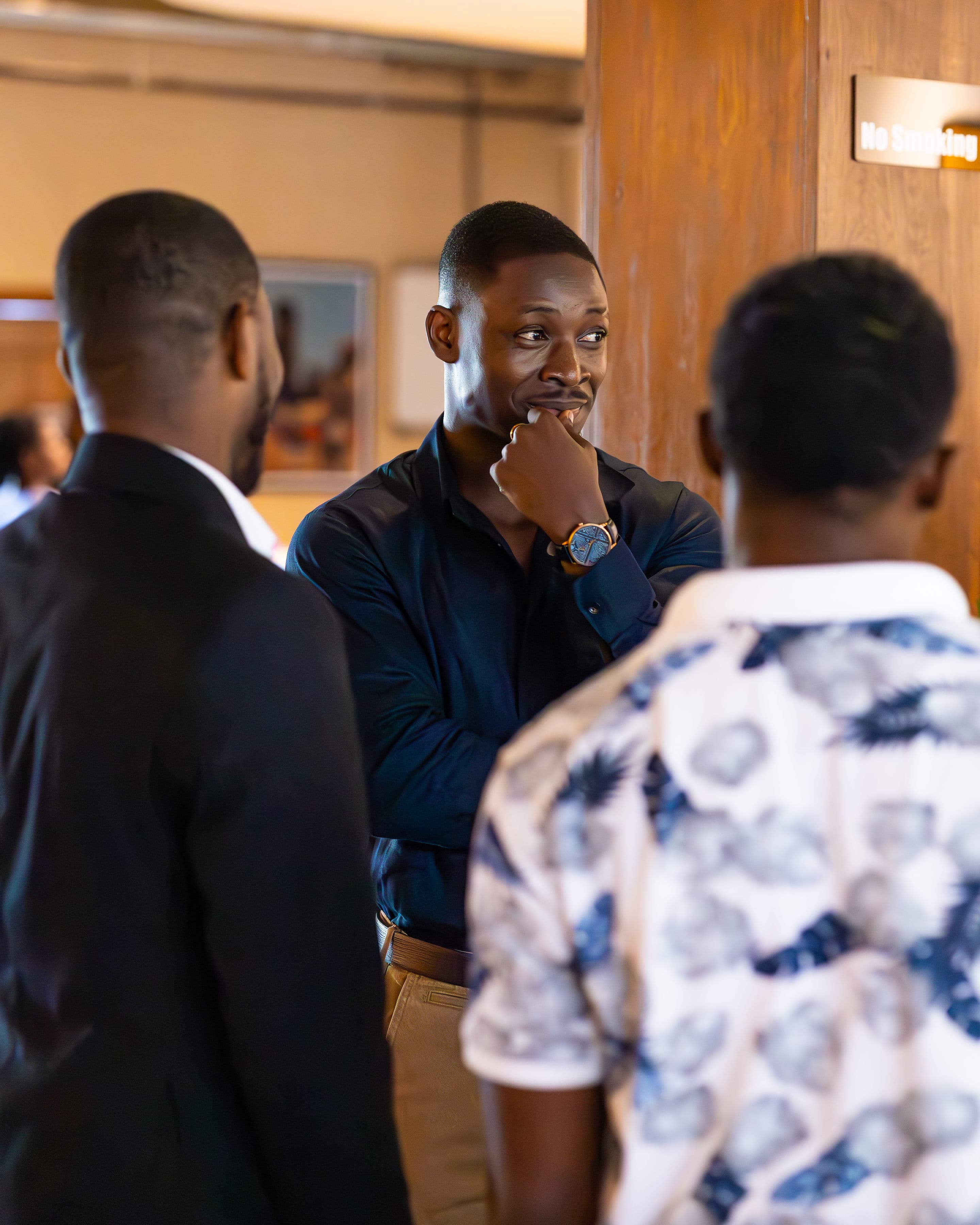 Three attendees standing in discussion during a break
